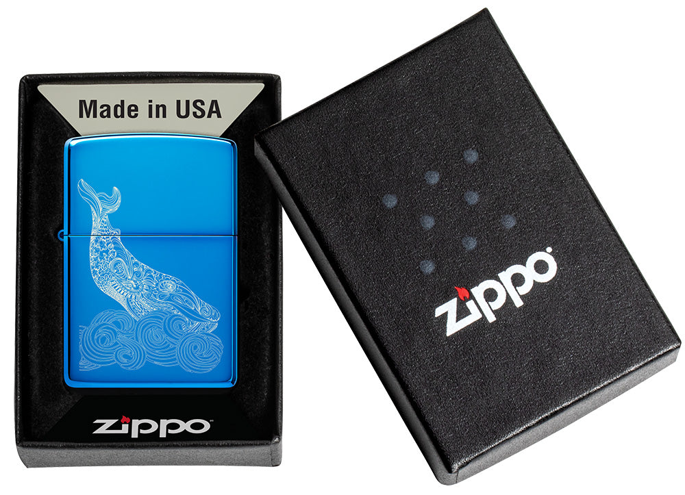 Zippo Lighter Whale Design shiny light blue in its open packaging with an engraved whale with round waves